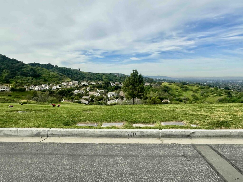 View of Vista lawn with curb signage at Forest Lawn Memorial Park Covina - Bayer Cemetery Brokers