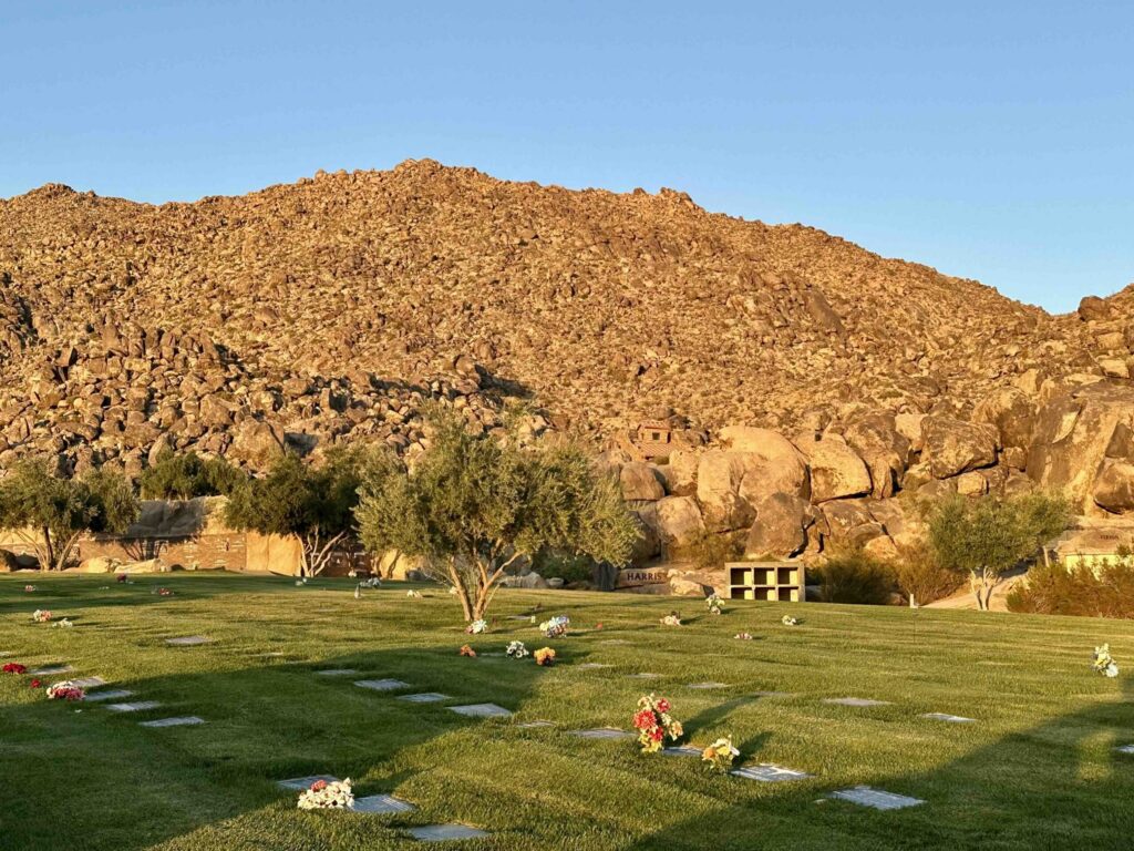 Golden hour warm tones red rock formation seen from the Eternal Rocks section at Sunset Hills Memorial Park Apple Valley - Bayer Cemetery Brokers